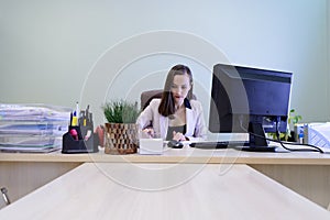 Young business woman working hard over the Desk in the study, economist accountant financial reporting, verifies accuracy of docum