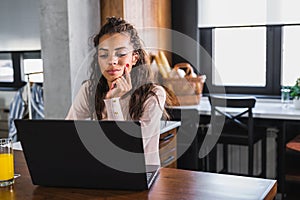 Young business woman working from home sitting in front of laptop computer having meeting over internet
