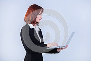 Young business woman working on laptop. Attractive mature businesswoman working on laptop