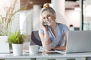 Young business woman working on laptop in office