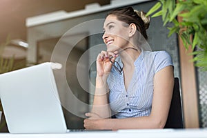 Young business woman working on laptop in office