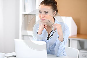 Young business woman working on laptop in office. Successful business concept.