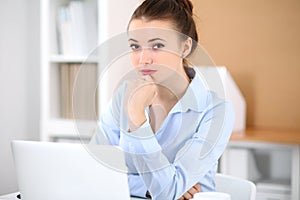 Young business woman working on laptop in office. Successful business concept.