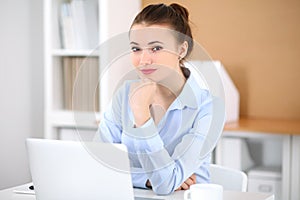 Young business woman working on laptop in office. Successful business concept.