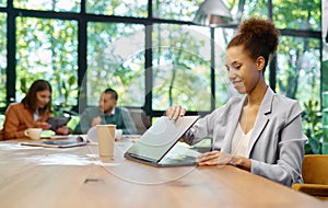 Young business woman working on laptop at shared open workspace