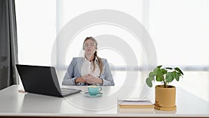 Young business woman working in the office on laptop listening the music on the headphones. Female businessperson enjoying her wor