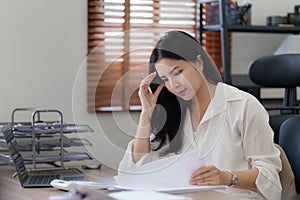 Young business woman working in office suffering from headache