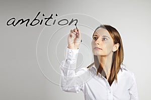 Young business woman writing ambition word