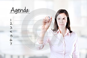 Young business woman writing blank agenda list.