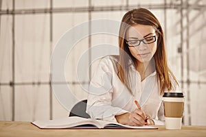 Young business woman writing in office