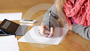 Young business woman writing pen on sheet of paper at office