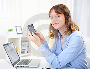 Young business woman writing a text on her mobile