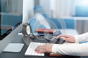 Young business women work with calculator and computer desktop on the modern work table at home office