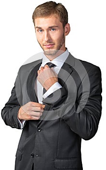 Young businessman adjusting his tie