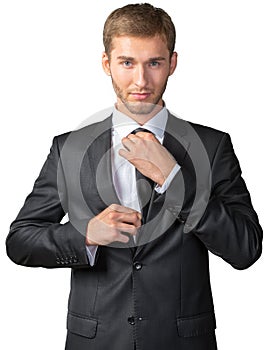 Young businessman adjusting his tie
