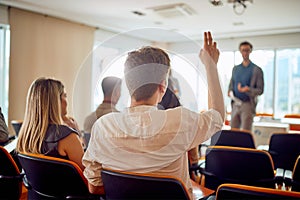 A young businessman asks a question during a business lecture in the conference room. Business, people, company