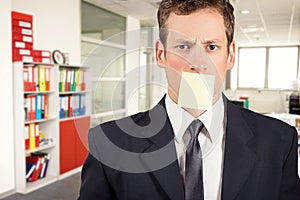 Young businessman with blank note on his mouth