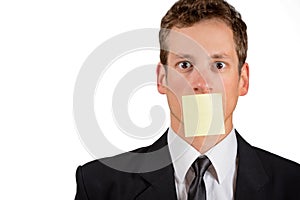 Young businessman with blank note on his mouth