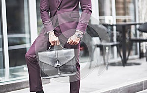 Young businessman with a briefcase near a beautiful office. Business meeting.