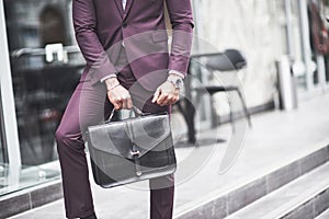 Young businessman with a briefcase near a beautiful office. Business meeting.