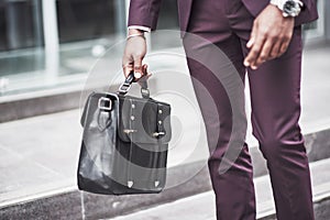 Young businessman with a briefcase near a beautiful office. Business meeting.