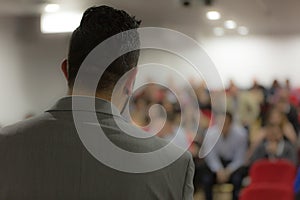 Young businessman at business conference room with public giving presentations. Audience at the conference hall. Entrepreneurship