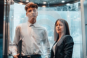 Young businessman and businesswoman in an elevator