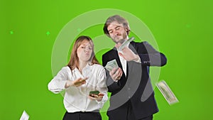 Young businessman and businesswoman standing in studio, posing with money.