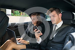 Young Businessman And Businesswoman Traveling In The Car