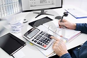 Young Businessman Calculating Bill In Office