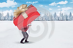 Young businessman carrying a big gift box