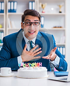 Young businessman celebrating birthday alone in office