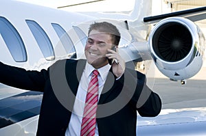 Young businessman on cell phone in front of corpor