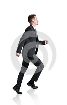 Young businessman climbing career ladder, isolated, side view