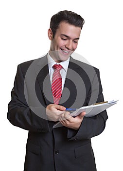 Young businessman with clipboard making notes