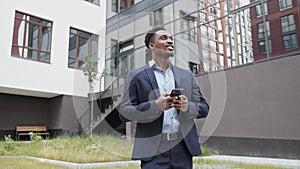 Young businessman communicating on smartphone smiling confident.