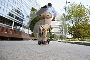 Young Businessman Commuting To Work Through City On Scooter