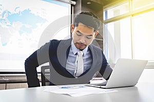 Young businessman concentrate working on laptop with windows background