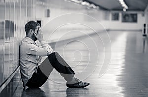 Young businessman crying abandoned lost in depression sitting on ground subway