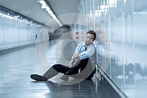 Young businessman crying abandoned lost in depression sitting on ground subway