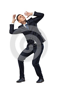 Young businessman in defensive pose afraid of something isolated on white background
