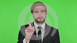 Young Businessman in Denial on Green Background