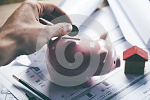 Young businessman depositing money in piggy bank