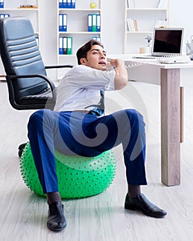 Young businessman doing sports stretching at workplace