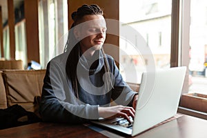 Young Businessman with dreadlock having doing his work in cafe with laptop
