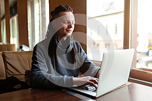 Young Businessman with dreadlock having doing his work in cafe with laptop