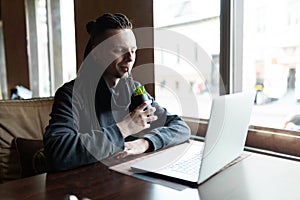 Young Businessman with dreadlock having doing his work in cafe with laptop