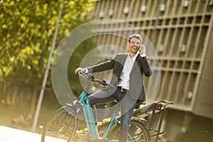 Young businessman on the ebike using mobile phone