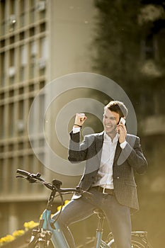 Young businessman on the ebike using mobile phone