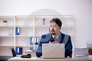 Young businessman employee and too much work in the office